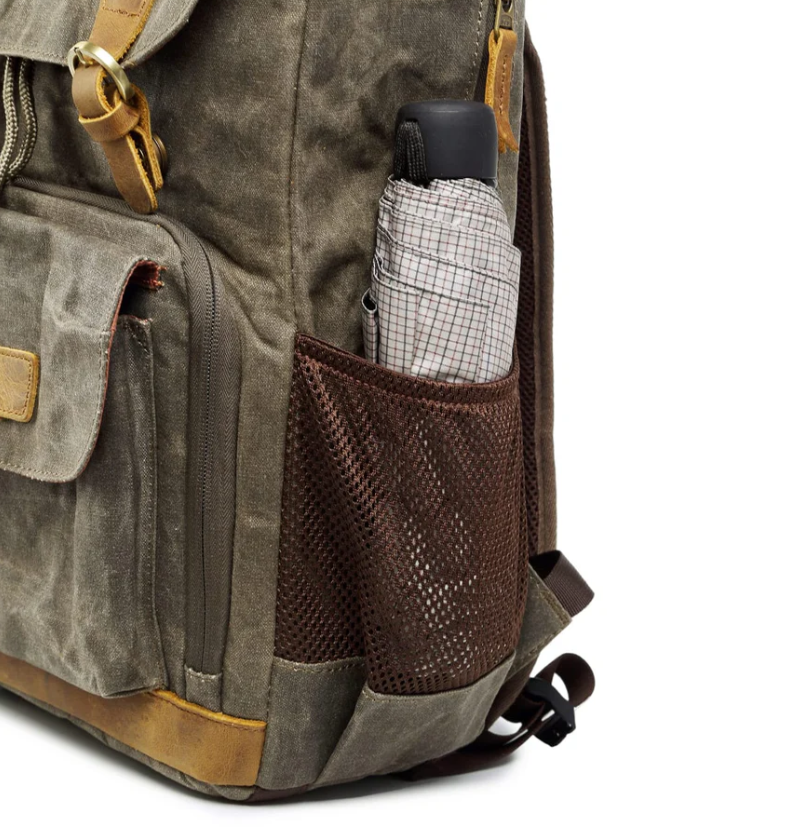 Waterproof canvas camera backpack showcasing a side pocket with an umbrella, perfect for outdoor photography adventures.