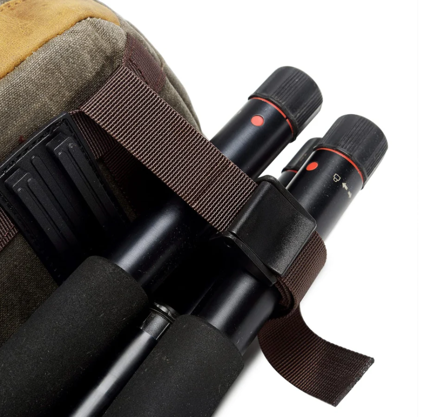 Close-up of waterproof canvas camera backpack showing tripod straps and secure hold for outdoor photography equipment.