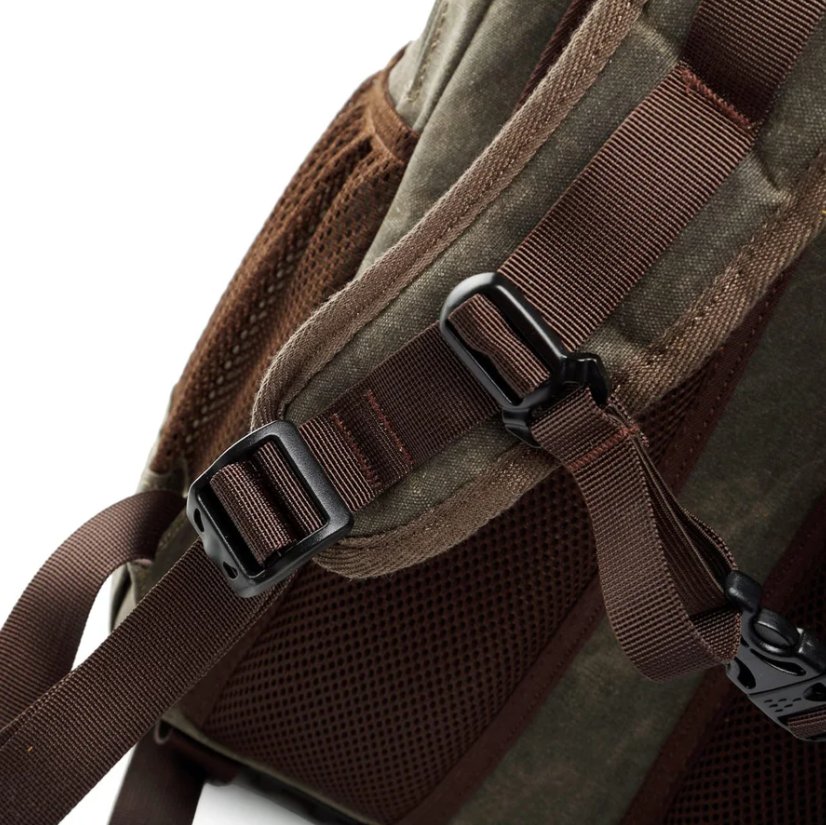 Close-up of waterproof canvas camera backpack straps and buckles, designed for durability and comfort during outdoor adventures.