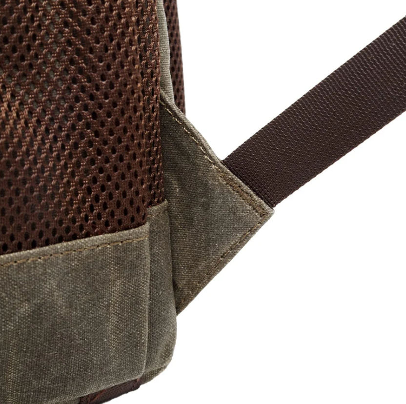Close-up of waterproof canvas camera backpack shoulder strap and textured fabric for outdoor photography.