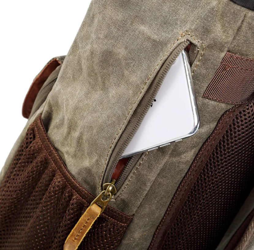 Close-up of the waterproof canvas camera backpack showing a pocket with a phone inside.