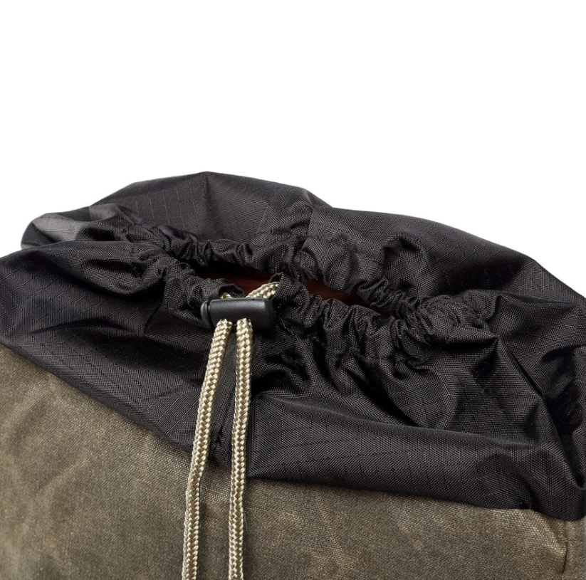 Close-up of waterproof canvas camera backpack top with drawstring closure, designed for outdoor photography.