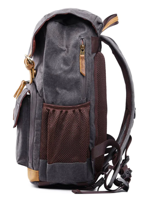 Waterproof canvas camera backpack in gray with brown accents, side view showcasing pockets and straps.