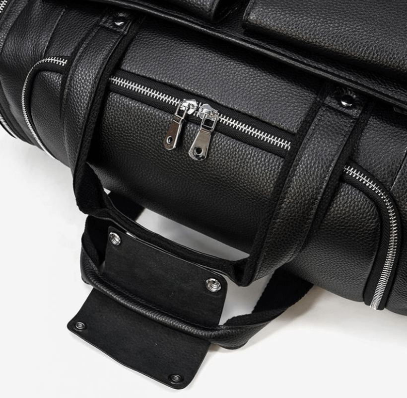 Black leather duffle bag with zippers and sturdy handles, ideal for travel or gym use.