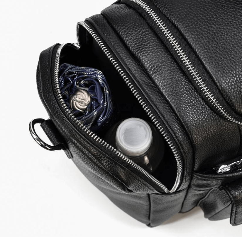 Interior view of a black leather duffle bag showcasing its spacious compartments with a water bottle and an umbrella.
