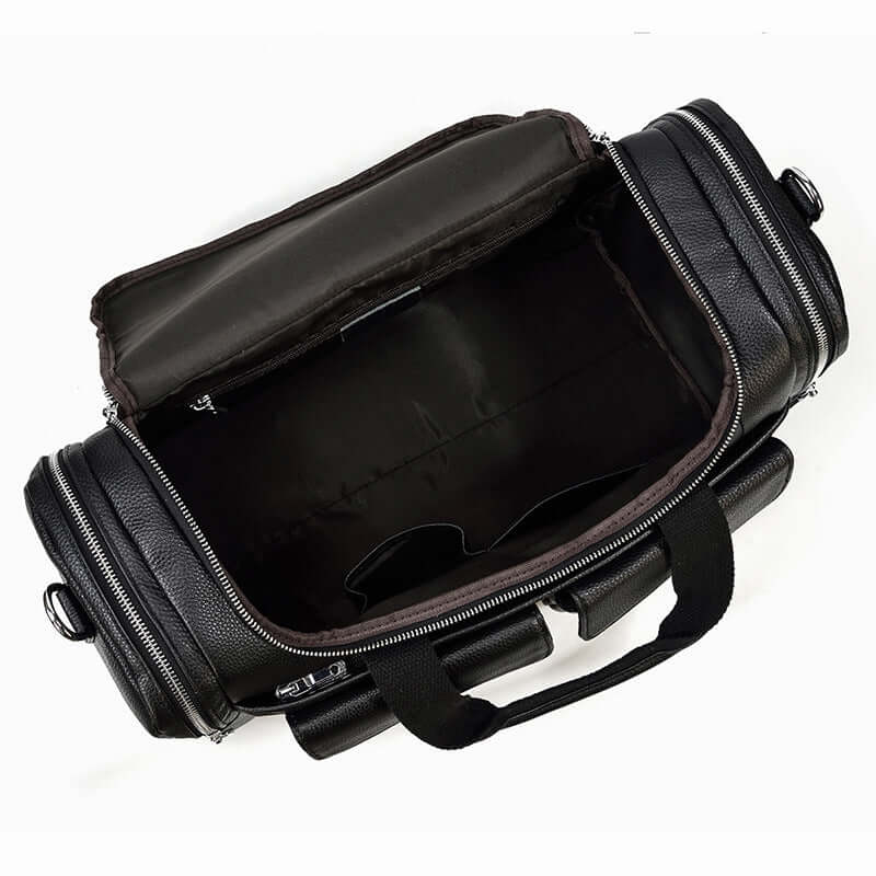 Interior view of a spacious black leather duffle bag featuring zippers and sturdy handles, perfect for travel.