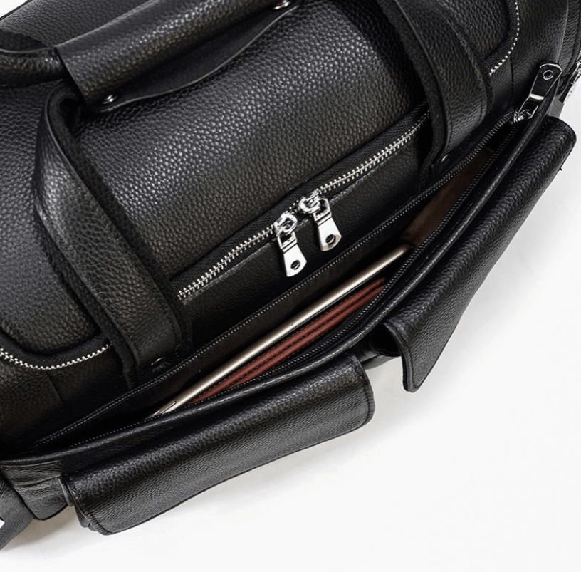 Stylish black leather duffle bag with dual zippered compartments, ideal for travel and everyday use.