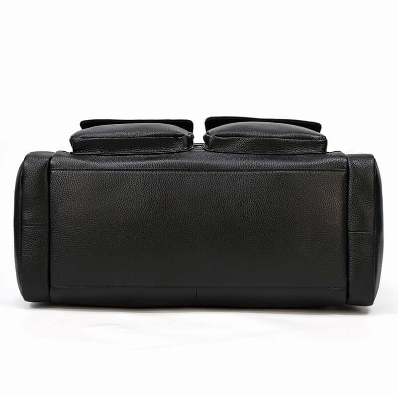 Black leather duffle bag bottom view with two zippered pockets, showcasing premium craftsmanship and design.
