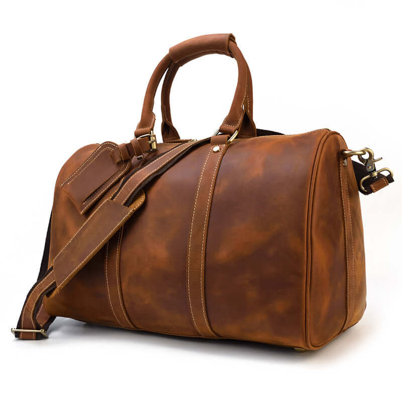 Stylish leather duffle bag in brown color with adjustable strap, perfect for travel and outdoor adventures.