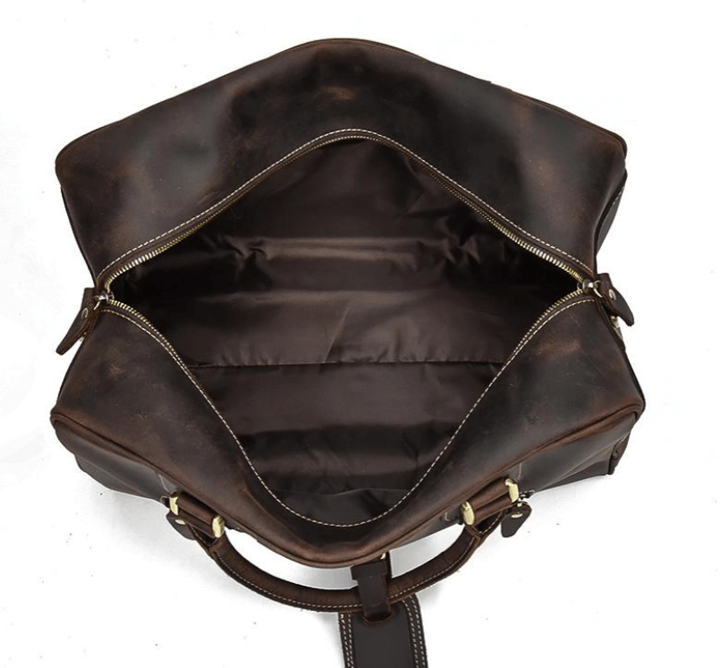 Interior view of the leather overnight bag showing spacious compartments and a rich brown lining, ideal for travel.